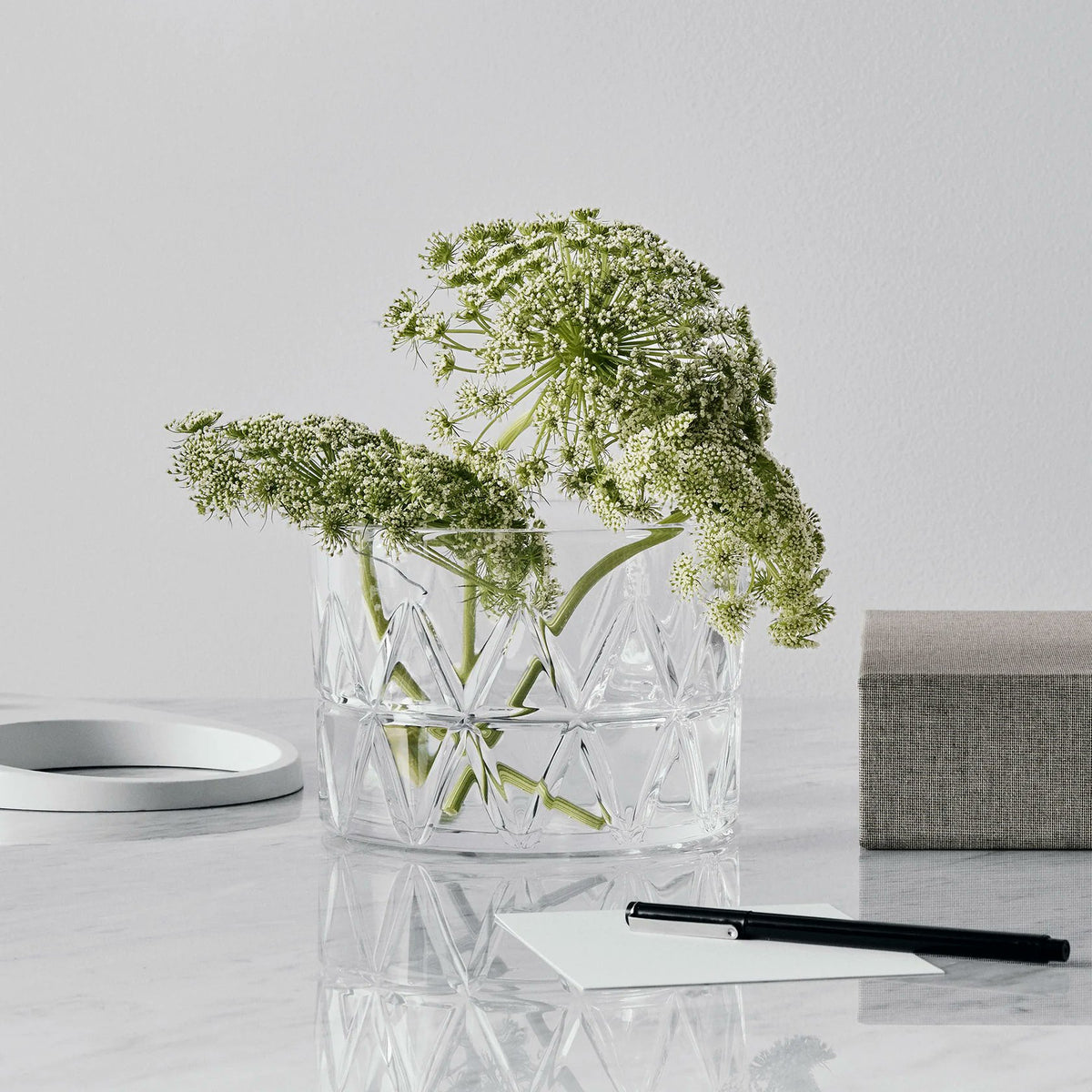 Orrefors Peak Bowl styled with floral stem on side table