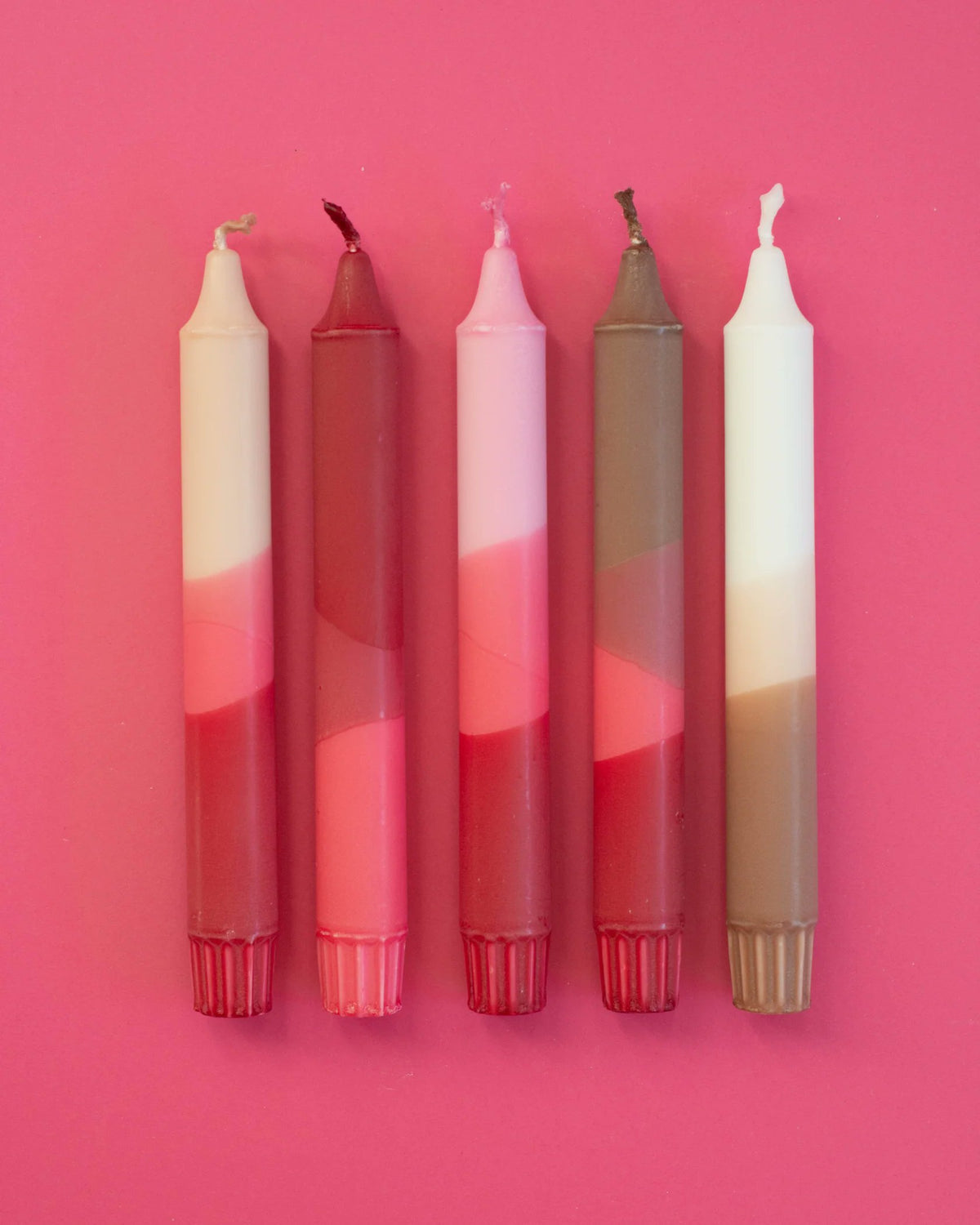 Nordtrice nude pink ribbon taper candles 5-pack standing upright on pink background