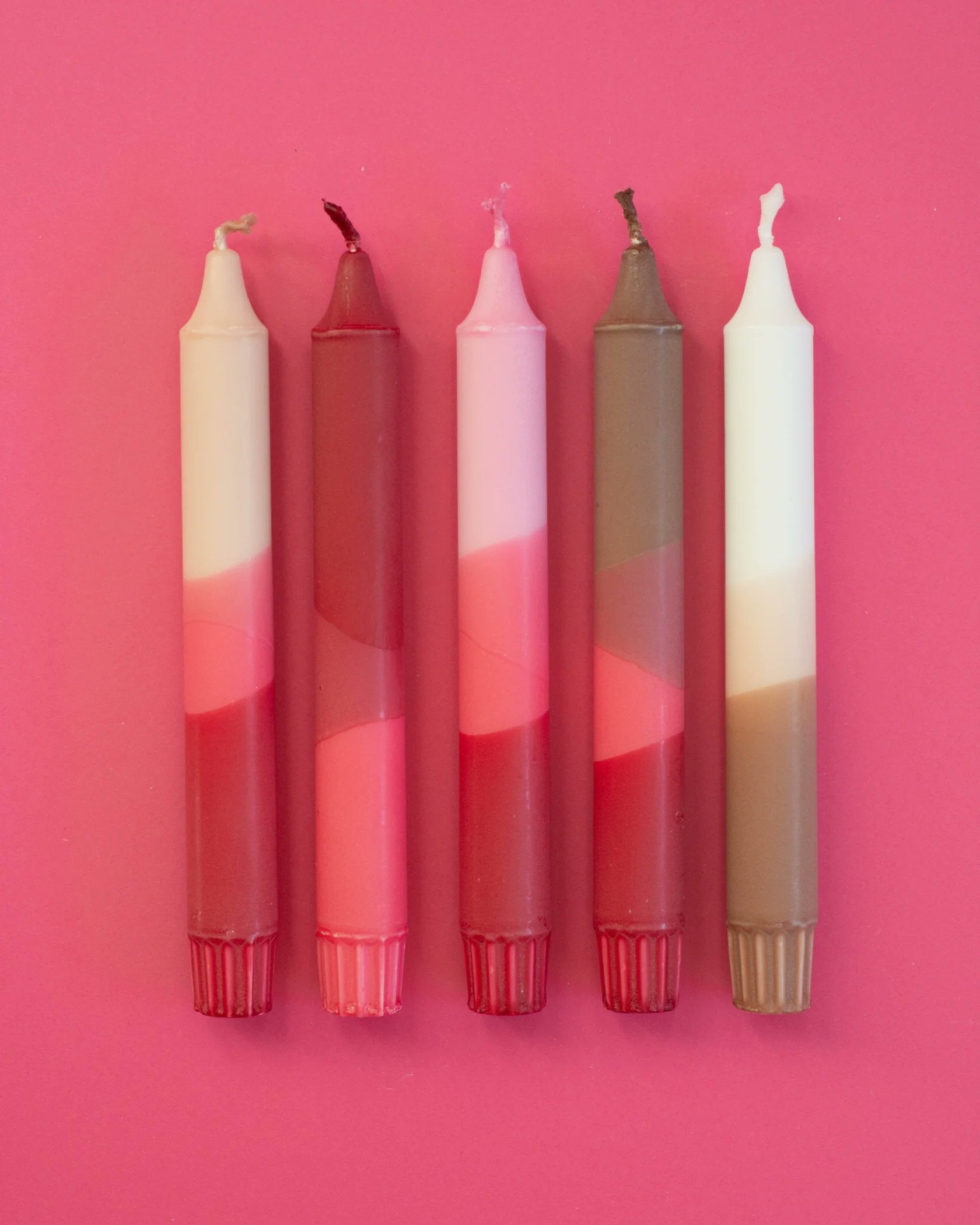 Nordtrice nude pink ribbon taper candles 5-pack standing upright on pink background