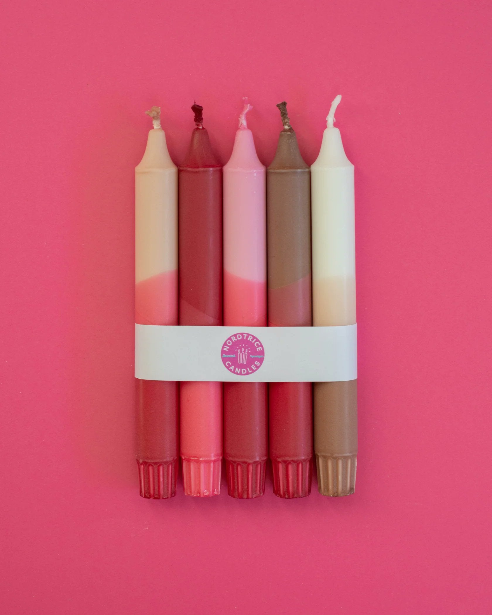 Nordtrice nude pink ribbon candles 5-pack top-down view on pink surface