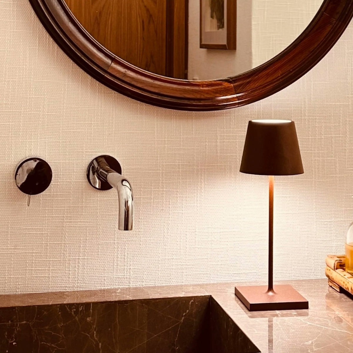 Zafferano Poldina Pro Mini black cordless lamp styled on dark surface dramatic indoor lighting