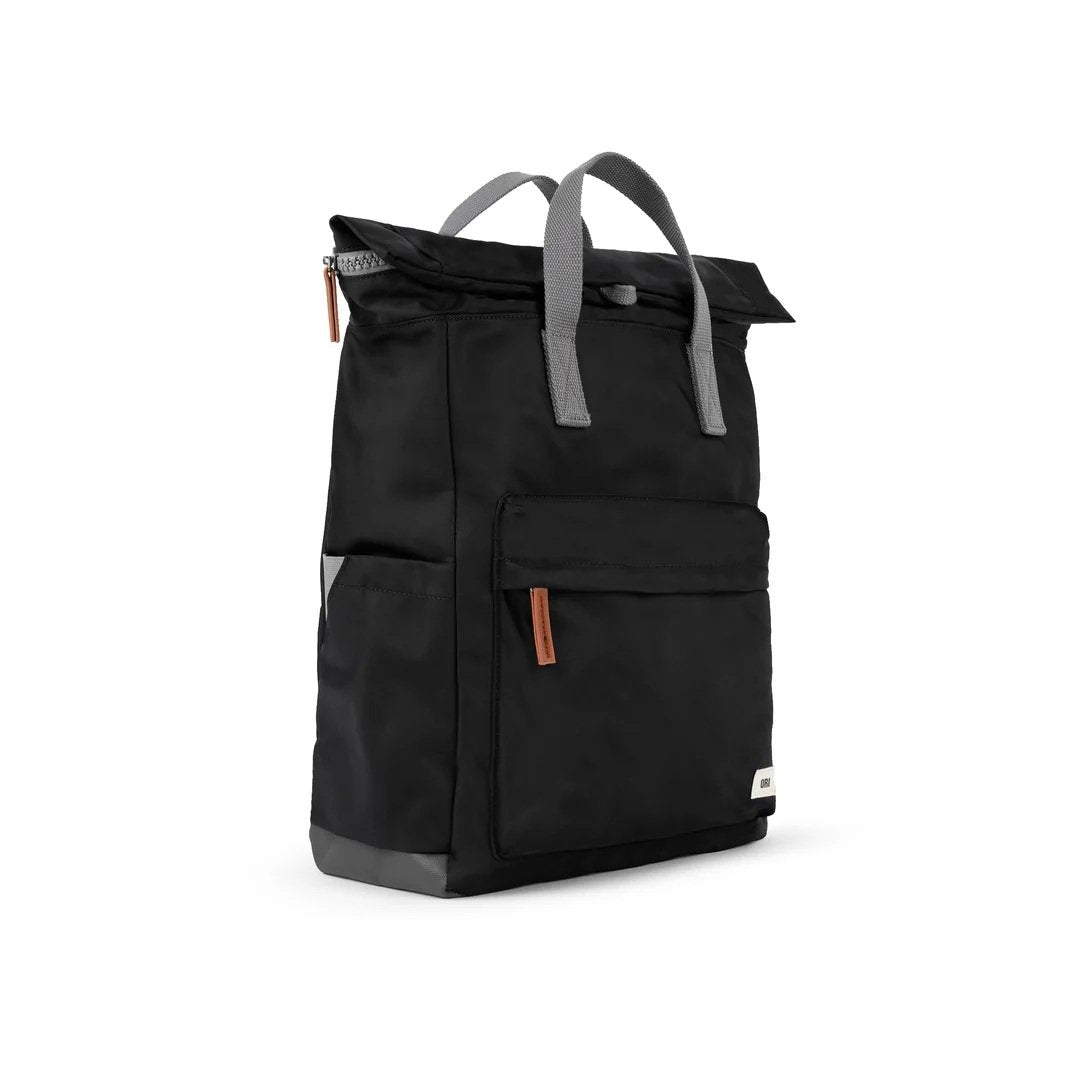 Close-up of weatherproof black roll-top backpack with triple-coated canvas base