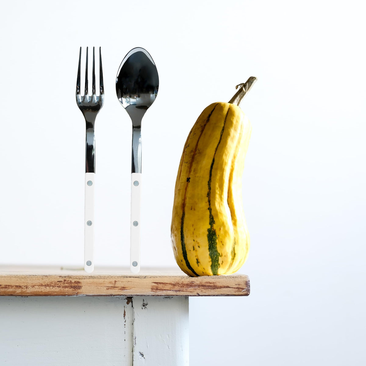 Sabre Paris Bistrot white serving fork and spoon in a holder with a banana